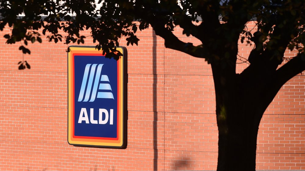 The side of an Aldi with a tree