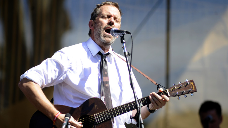 Hugh Laurie playing guitar on stage