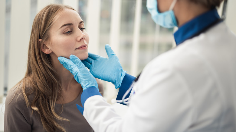 Doctor examining tonsils, a human body part