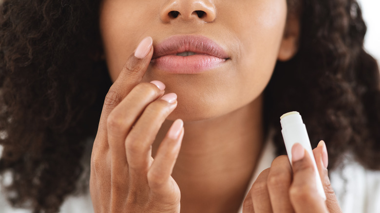 woman applies lip balm