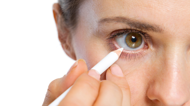 Applying white eyeliner