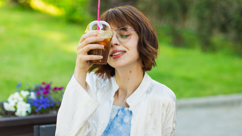 woman holding coffee near face