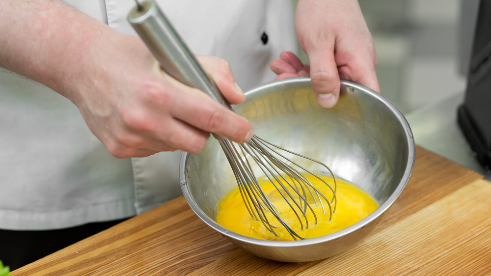 A chef scrambling raw eggs