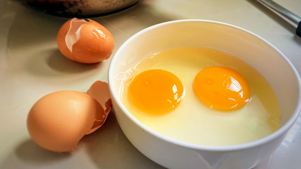 Raw eggs in a bowl with shells