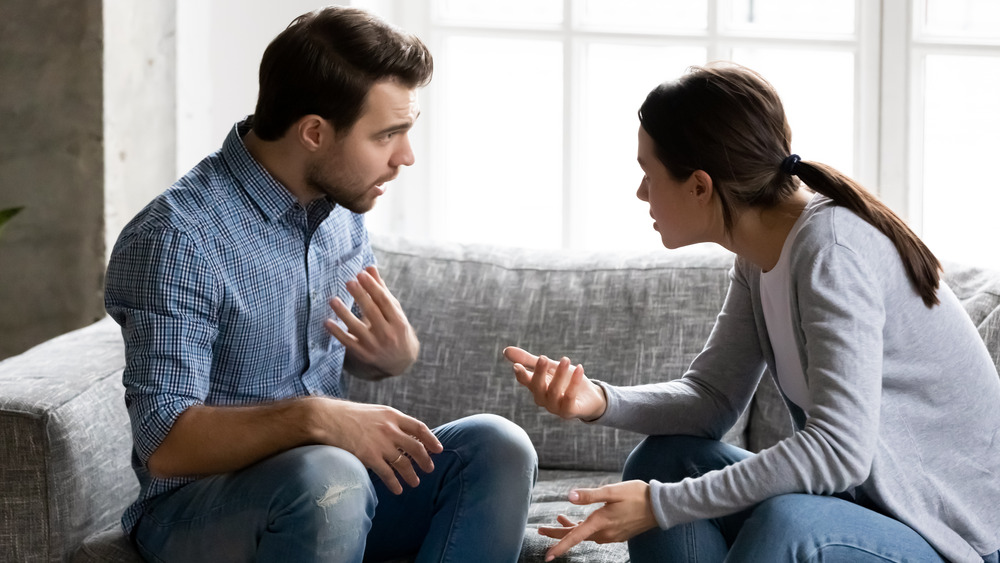 Couple sitting on couch arguing