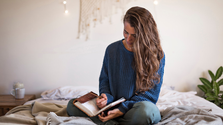 Woman journaling in bed