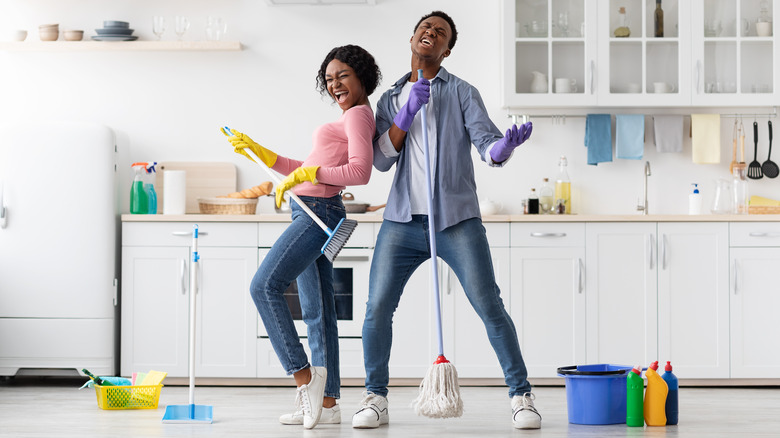 Couple singing and cleaning together