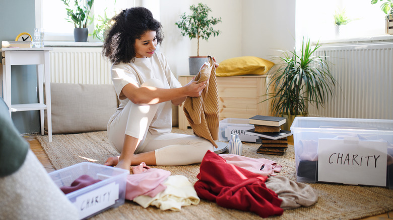 woman sorting through clothes to donate