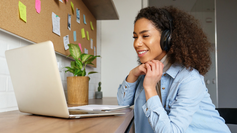 Woman smiling while studying at her computer