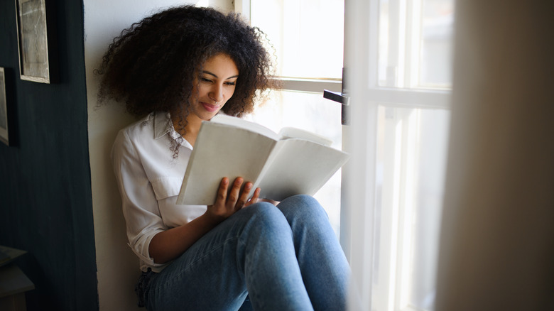 Young woman reading a book indoors