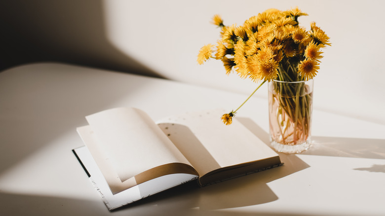 book open with flowers next to it