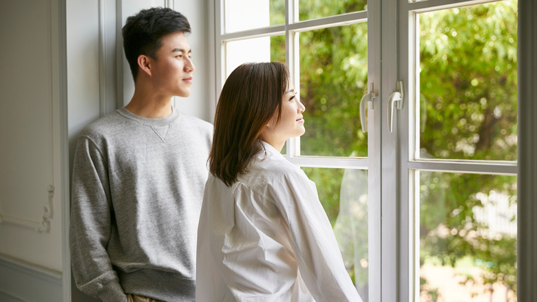 Couple standing by window