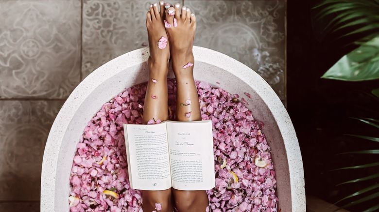 book open on a woman's legs while she's in the bath