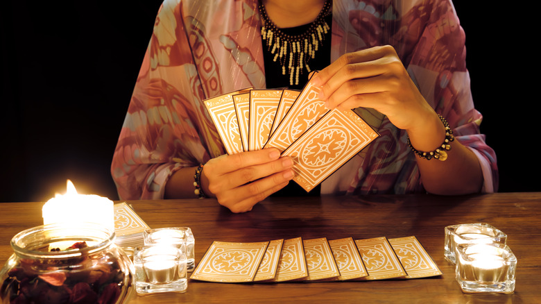 Woman reading tarot cards with candles