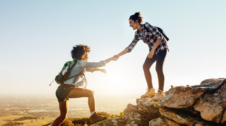 Two friends hiking up rocks