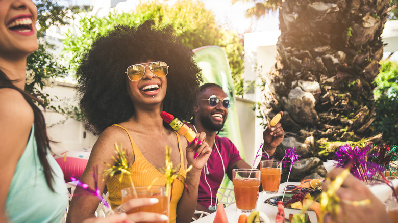 Group of friends partying with fruit and cocktails