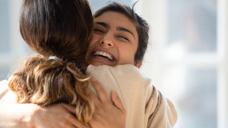 Two friends laughing and embracing