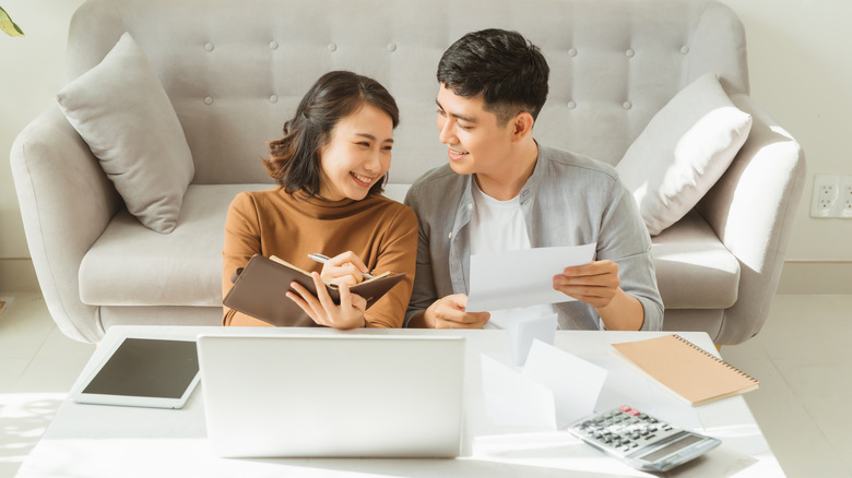 Couple looking over finances with agenda and calculator