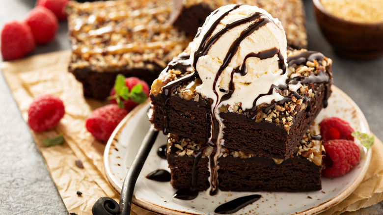 Brownies topped with ice cream and chocolate syrup 