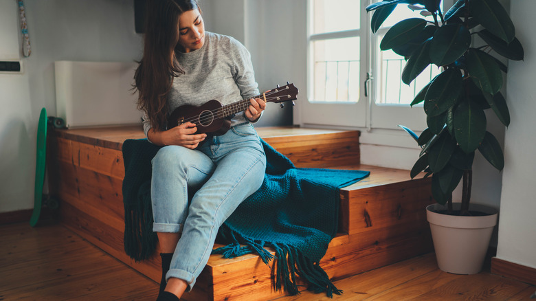 Young woman playing ukulele 