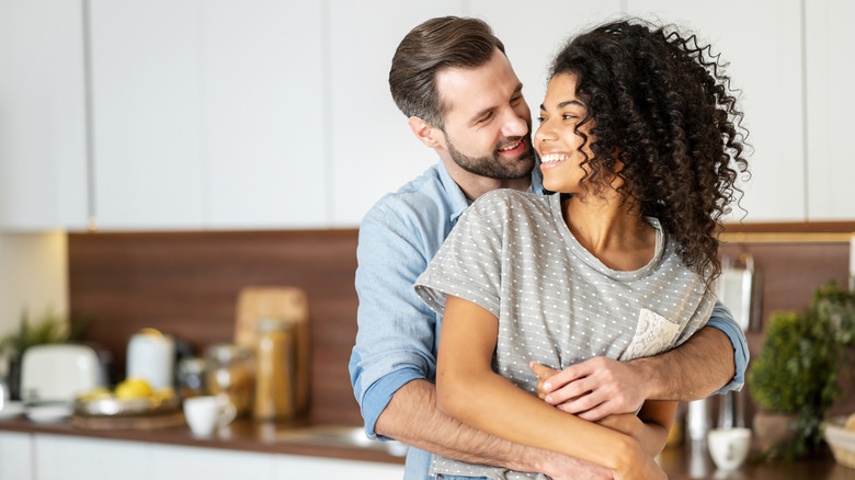 woman and man hugging close and smiling