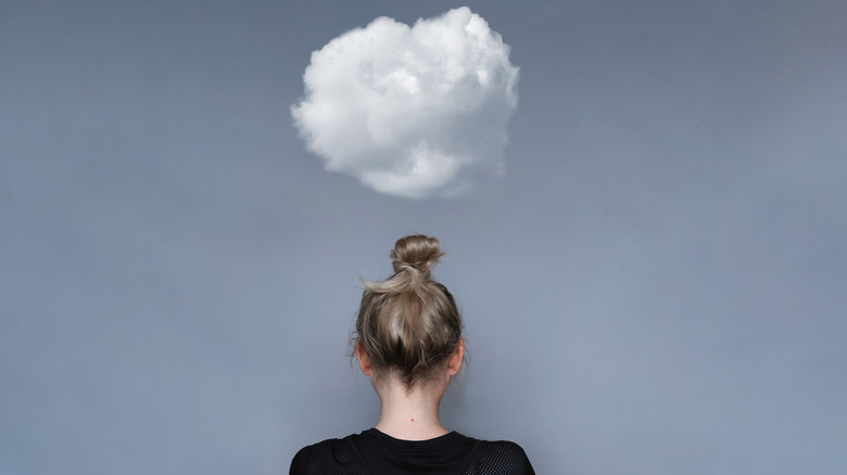 woman facing backward with a cloud above her head