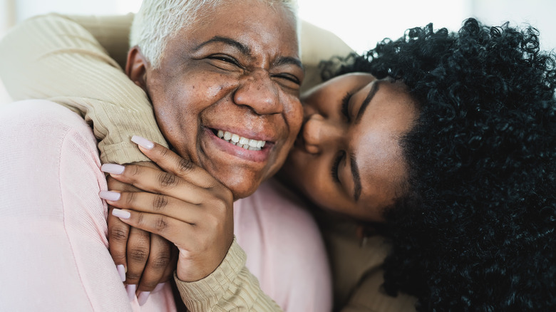 Young woman kissing her mom on cheek