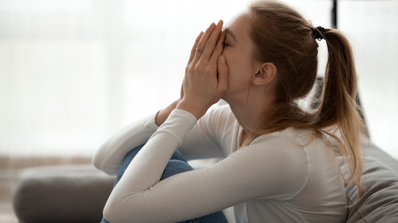 Young woman with hands on face