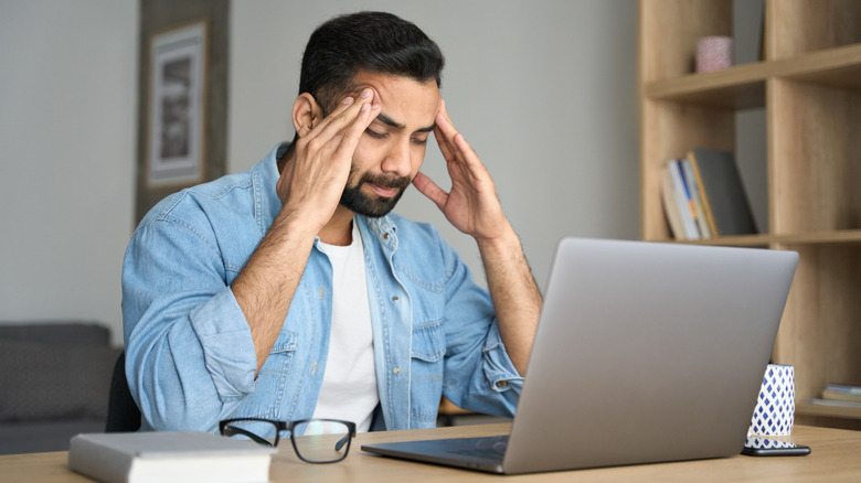 man having a headache while working