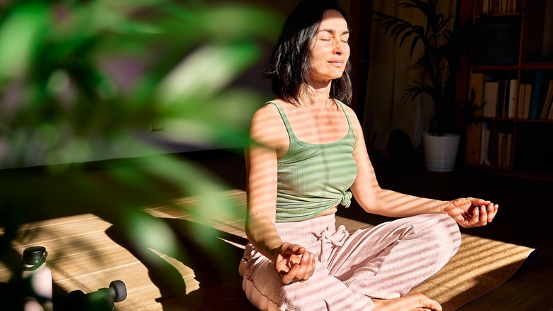 Someone sitting in a shadowy room meditating