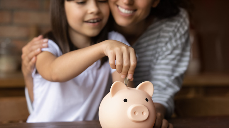 Mother teaching daughter to save