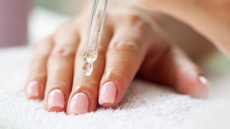 Woman putting oil on nails 