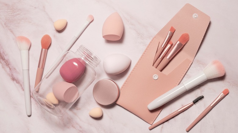 Pink makeup tools on marble background