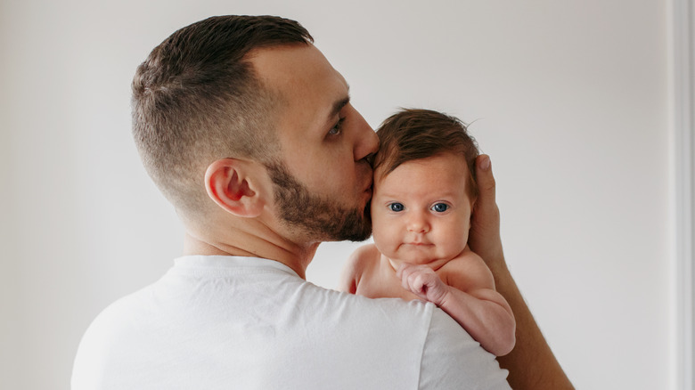 Father holding, kissing baby boy