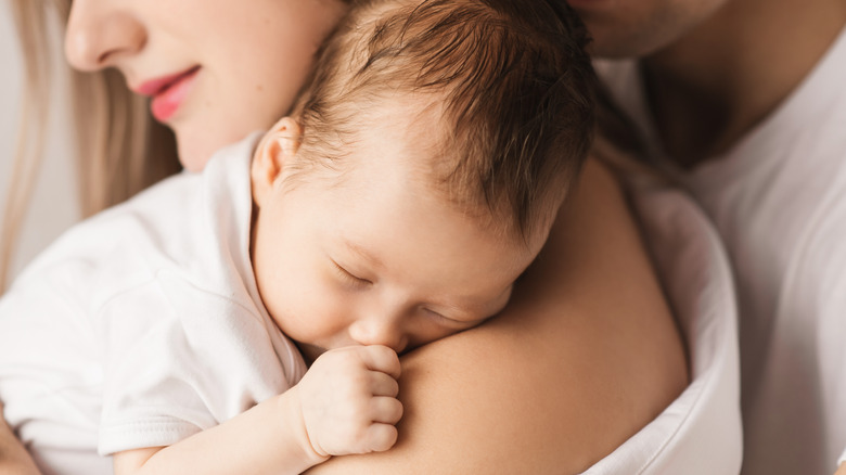 Woman holding sleeping baby boy