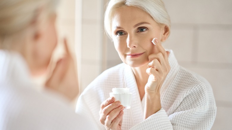 Older woman using face cream