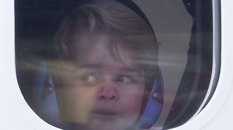 Prince George looking out of the window on a sea plane