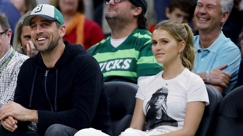 Aaron Rodgers and Mallory Edens sitting courtside