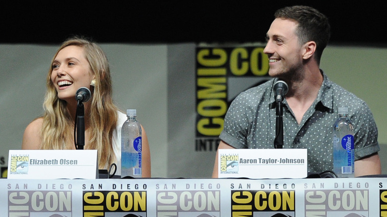 Elizabeth Olsen and Aaron Taylor-Johnson smiling on panel