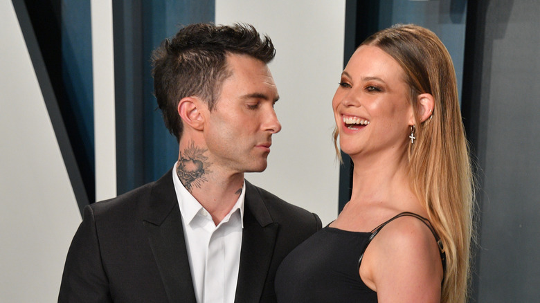 Adam Levine and Behati Prinsloo posing for photos in formal attire