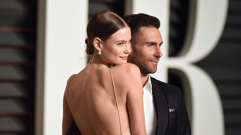 Behati Prinsloo in backless dress with Adam Levine