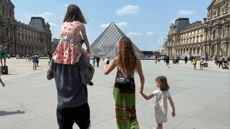 Adam Levine and Behati Prinsloo walking toward the Louvre Museum 