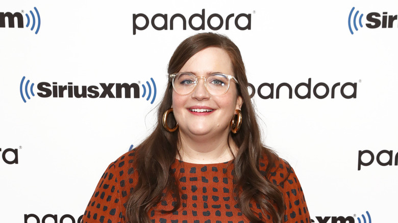 Aidy Bryant wearing glasses, smiling 