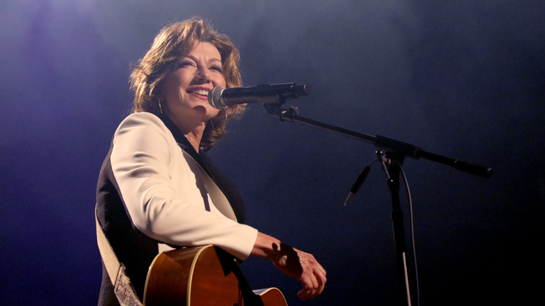 Amy Grant singing with a guitar