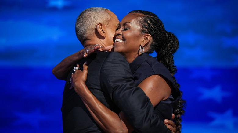 Barack and Michelle Obama hugging on stage at the DNC