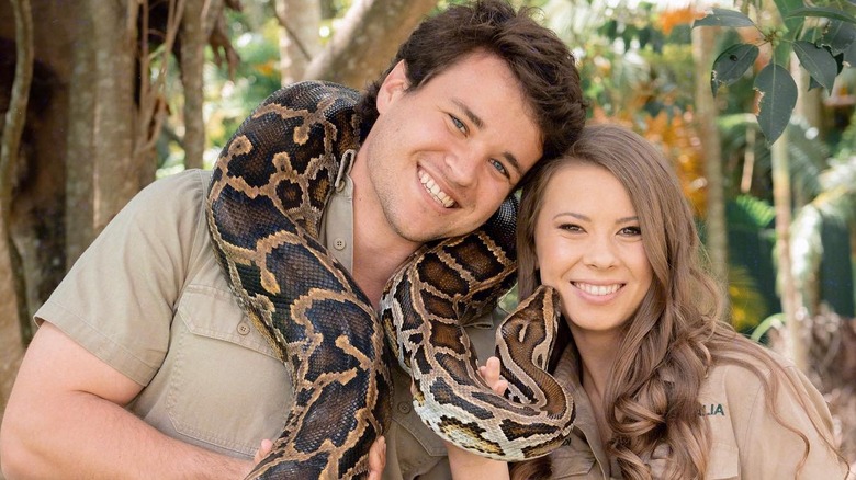 Bindi and Chandler holding a python