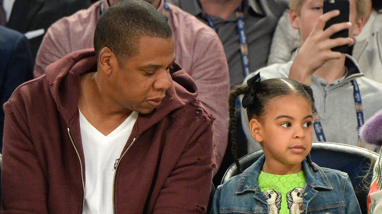 Jay-Z looking at Blue Ivy, both seated