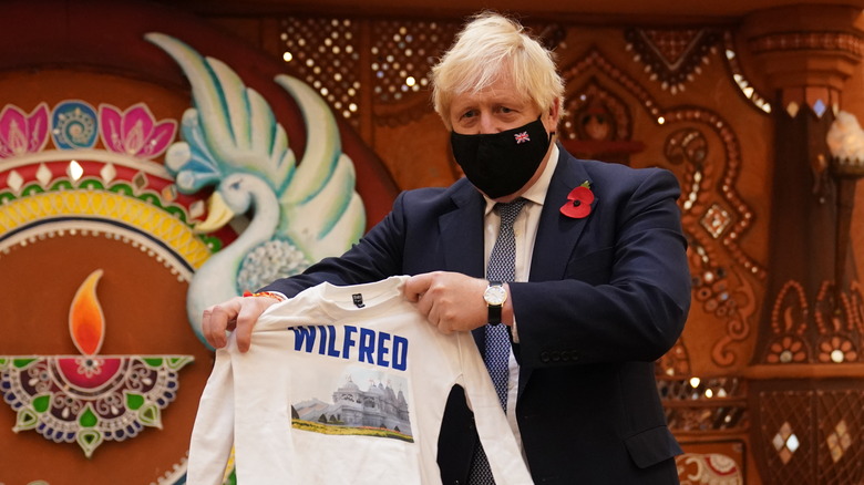 Boris Johnson holding a shirt that says Wilfred