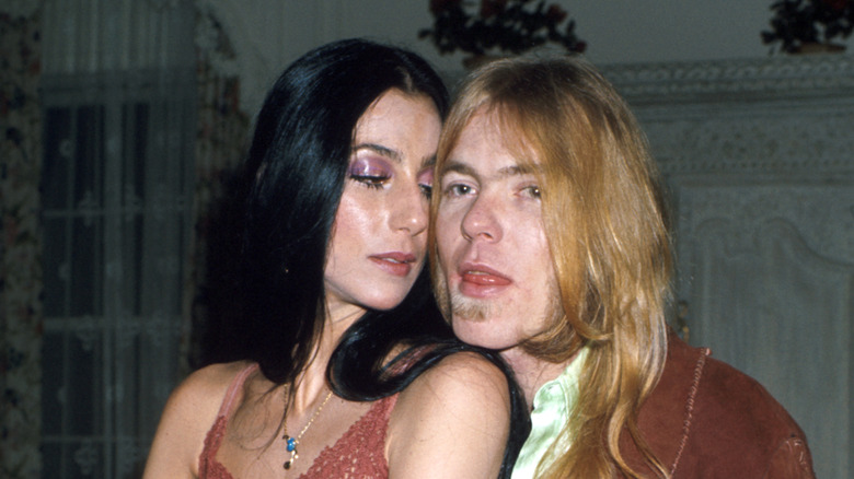 Cher looking at Gregg Allman while their bodies are close together