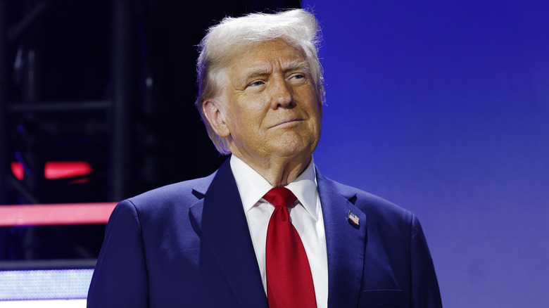 Donald Trump smiles in a navy suit and red tie